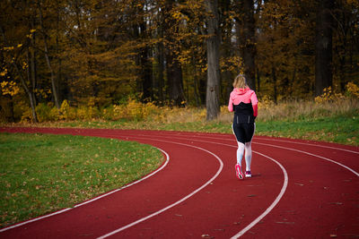 Full length of young man running on field