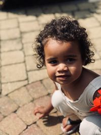 Portrait of cute baby girl on footpath