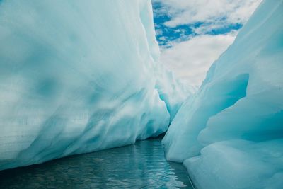 Icebergs on sea against sky during winter