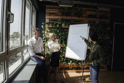 Business people working with flip chart in green office