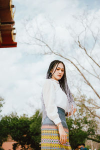 Woman standing against tree