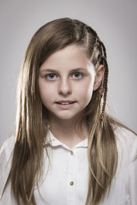 Portrait of smiling girl against gray background