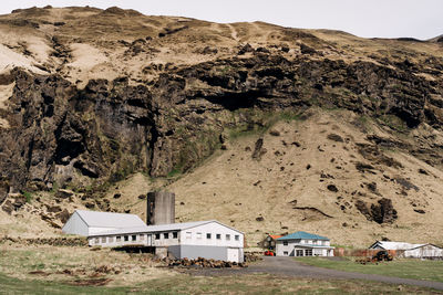 Houses by mountain against clear sky