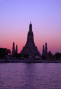 Silhouette of temple of dawn or wat arun at  stunning sunset, the best known landmark of thailand