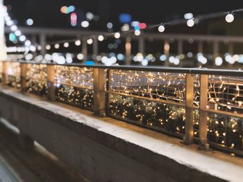 Illuminated lights on railing in city at night