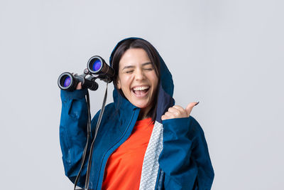 Portrait of young woman standing against white background