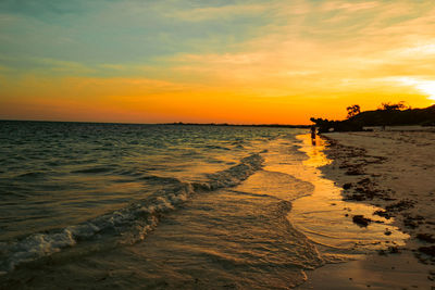 View of tourist walking on the sand at watamu beach at sunset in watamu, malindi, kenya