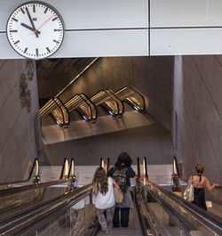 Rear view of people standing on staircase