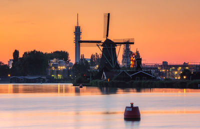 Industry and traditional windmill near the zaanse schans at sunset