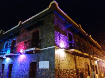 Low angle view of illuminated building against sky at night