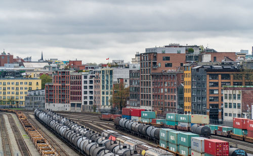 Railroad tracks amidst buildings in city against sky