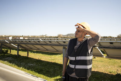 Tired male engineer taking break while working at solar power station