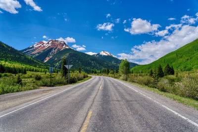 Road amidst trees against sky