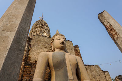 Low angle view of buddha statue against building