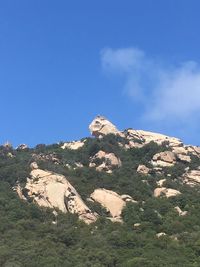 Low angle view of rocks on mountain against sky