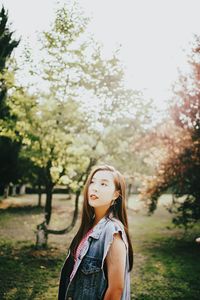 Portrait of woman standing against trees