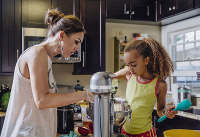 Mother and daughter baking in kitchen