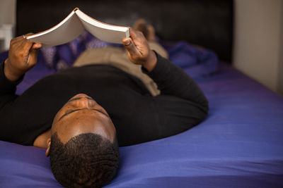 Low section of woman lying on bed at home