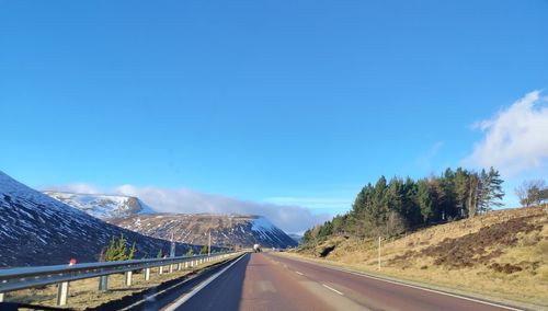 Road leading towards mountains against sky