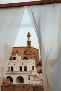 Historic building seen through curtain against sky