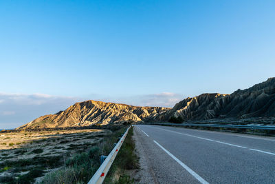 Empty road by mountain against sky