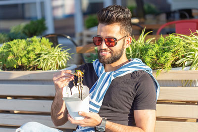 Young man drinking glass with sunglasses