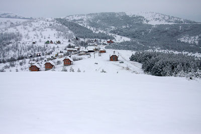 Panoramic view of snow covered field against sky