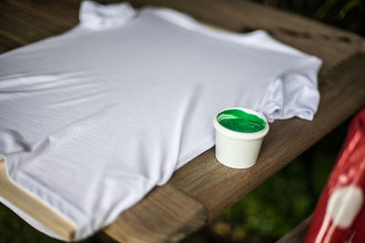 Close-up of white shirt with paint in cup