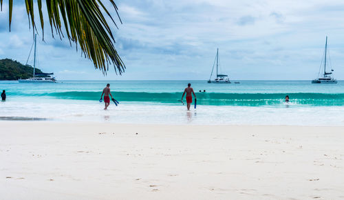 People on beach against sky