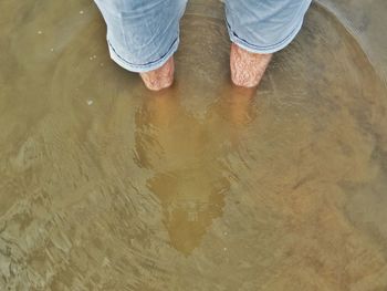 Midsection of man standing in water