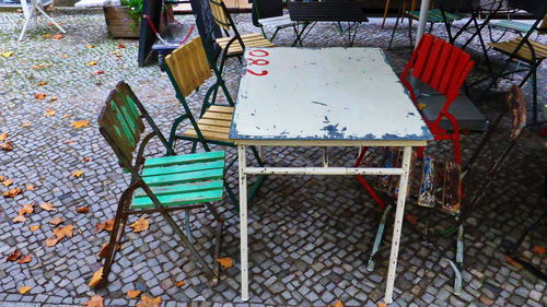 High angle view of empty chairs and tables at sidewalk cafe