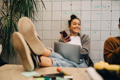 Smiling young woman using mobile phone