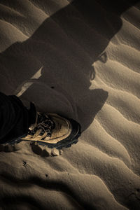 High angle view of person shadow on sand