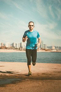 Full length portrait of man jogging at beach