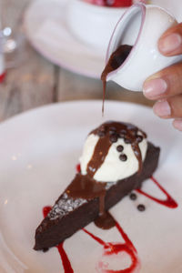 Close-up of hand holding chocolate cake