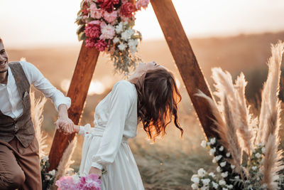 Rear view of women standing by plants on land