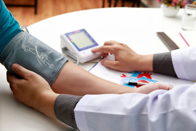 Midsection of woman using mobile phone on table