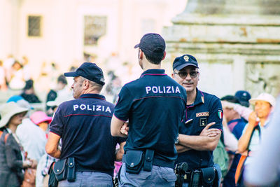 Rear view of people standing against graffiti