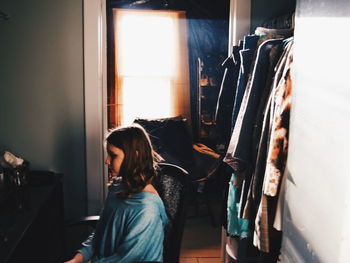 Woman sitting on window at home