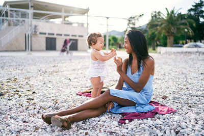 Full length of women sitting on beach