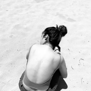 Black and white photograph. girl on sandy beach. 