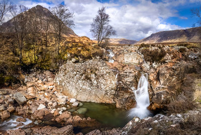 Scenic view of waterfall against sky