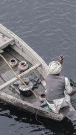 Rear view of man sitting in boat on lake