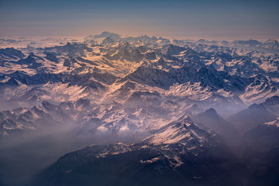 Aerial view of snowcapped mountains against sky