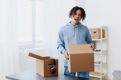 Portrait of young woman holding box