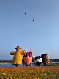 View of hot air balloons on land against sky