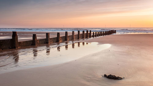 Scenic view of beach against sky during sunset