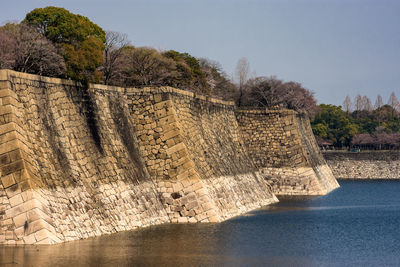View of stone wall by river