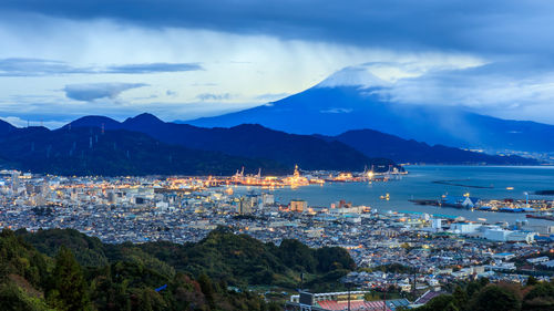 High angle view of city by sea against sky