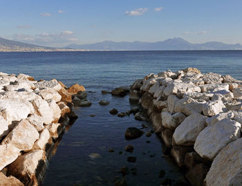 Rocks on sea shore against sky